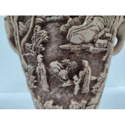 403 - Heavily carved oriental vase with landscape and figures depicted with the handles in the form of ele... 