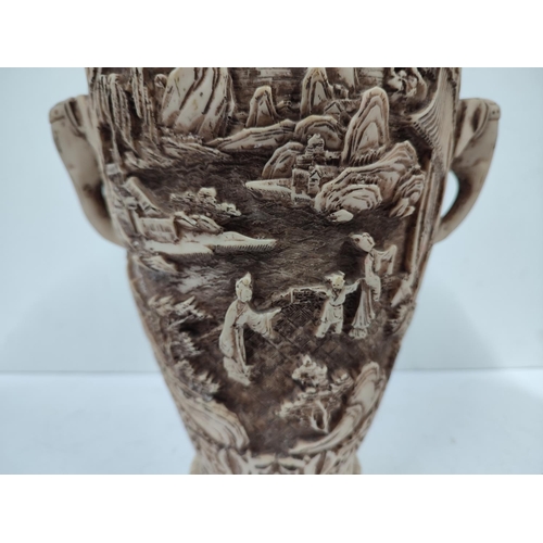 403 - Heavily carved oriental vase with landscape and figures depicted with the handles in the form of ele... 