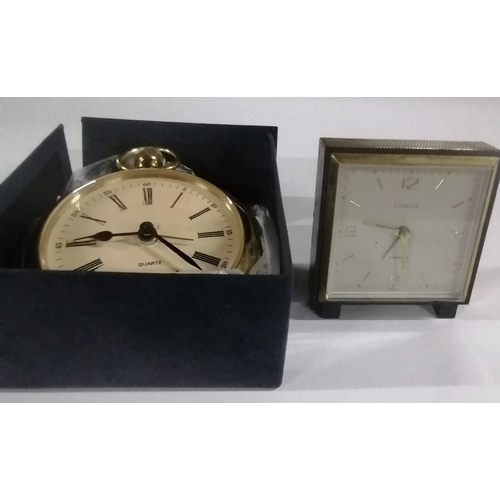 288 - Two alarm clocks, one shaped like a pocket watch