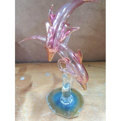 548 - Unmarked red glass, very fine figurine of 2 leaping Dolphins stood on an unusual rock crystal base