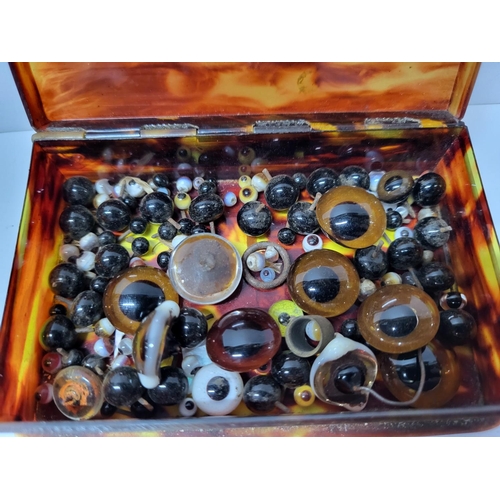 219 - Small antique tortoise shell box containing a quantity of antique glass eyes