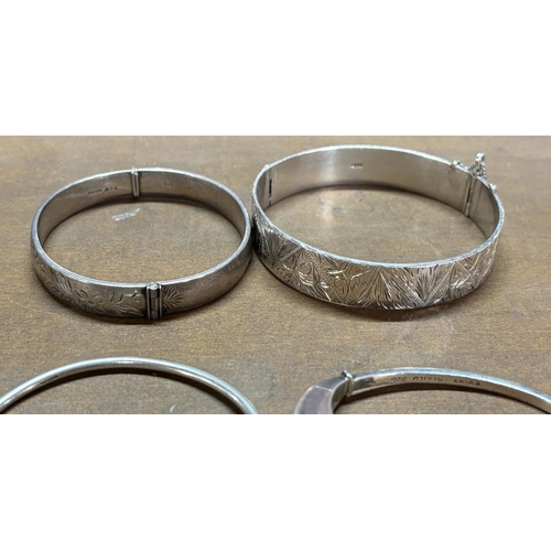 12 - Four silver bangles 1 finely carved (4)