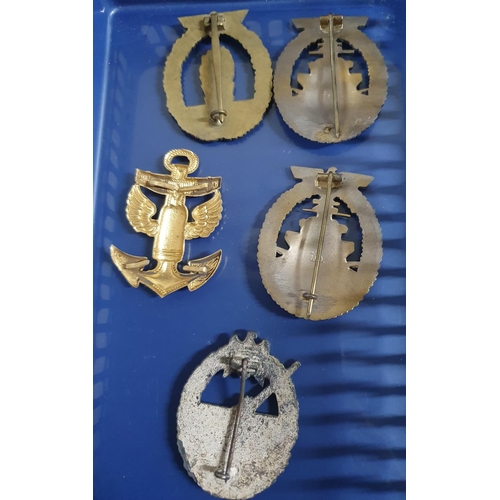 82 - Four German WWII Kriegsmarine cap badges together with a German WWII anti-tank cap badge (5),

Pleas... 