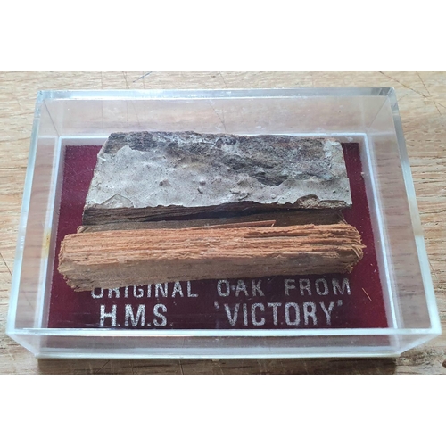 241 - Two small pieces of old Oak in a perspex case purporting to be from H M S Victory