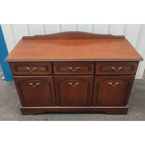 604 - A Rossmere sideboard comprising of three drawers above three doors with brass handles