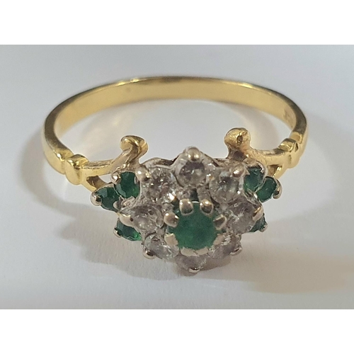 90 - yellow gold metal ring stamped 18kt with an Emerald and Diamond flower head caped with a central rou... 