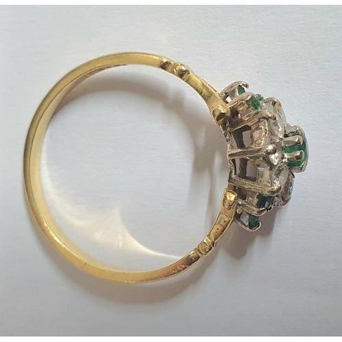 90 - yellow gold metal ring stamped 18kt with an Emerald and Diamond flower head caped with a central rou... 