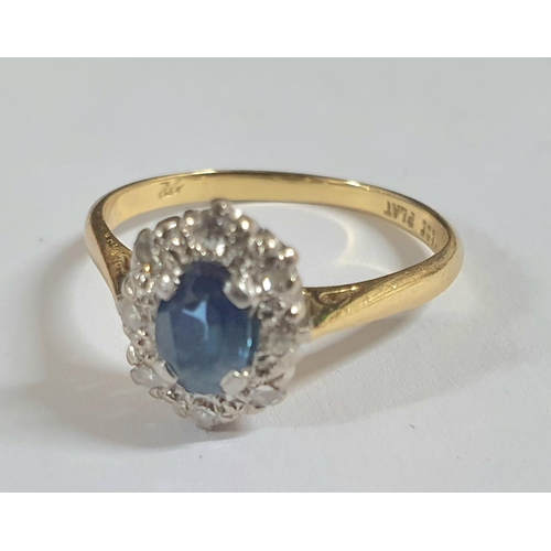 91 - Large oval cut Sapphire surrounded by smaller round cut diamonds, the yellow metal shank stamped 18C... 