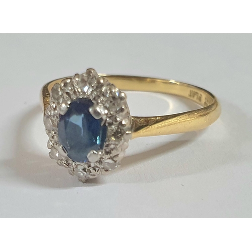 91 - Large oval cut Sapphire surrounded by smaller round cut diamonds, the yellow metal shank stamped 18C... 