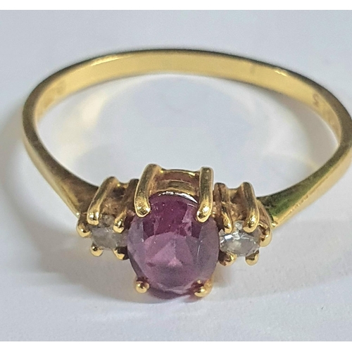 92 - Fully hallmarked 18ct yellow gold ladies ring with a large oval cut garnet flanked to either side by... 