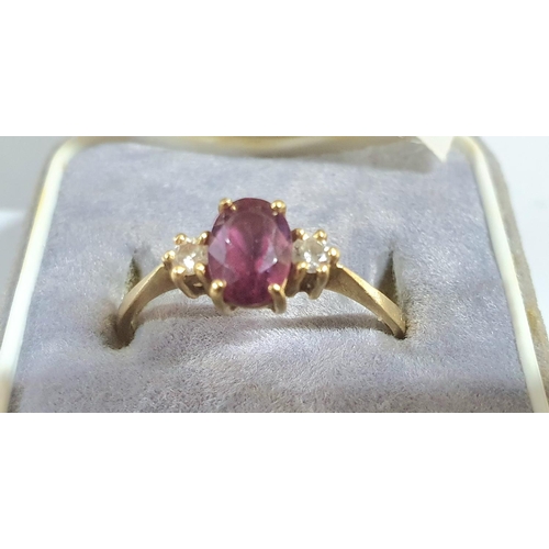 92 - Fully hallmarked 18ct yellow gold ladies ring with a large oval cut garnet flanked to either side by... 