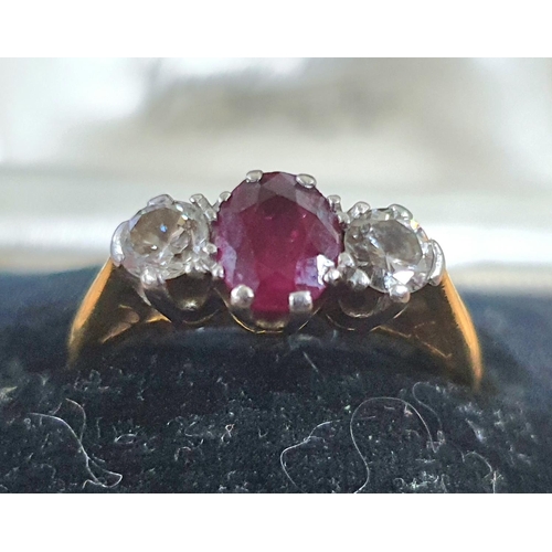 102 - 18ct gold ring with a large round cut Ruby flanked to either side by a round cut diamond and comes i... 