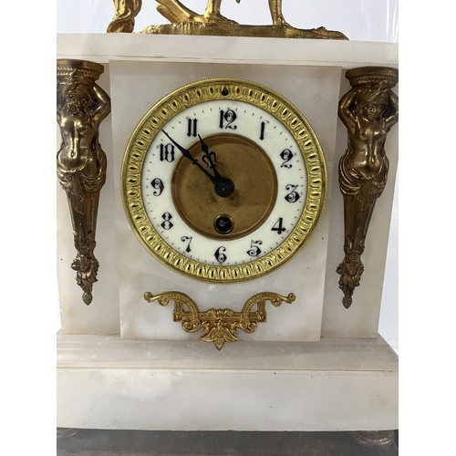 142 - Ornate French gilt mantle clock housed in huge glass dome with key