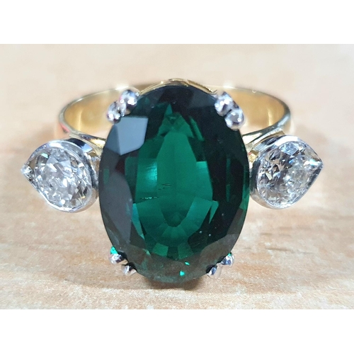 125 - 19.30ct oval Vivid Muzo Columbian green, recrystallised emerald master cut set in a ring with two si... 