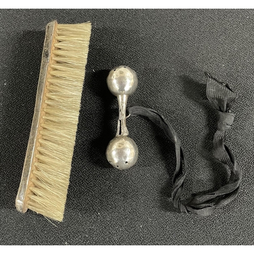 1 - A brush with a silver cap around it along with a silver baby toy