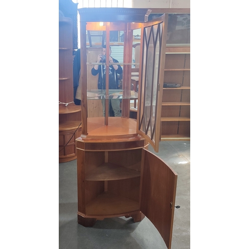 322 - A fine quality glazed burr-yew effect illuminating corner cabinet with glass inner shelves