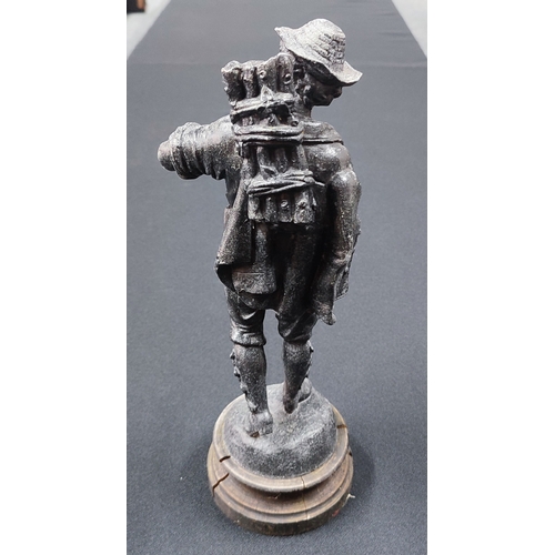 105 - An old heavy spelter sculpture on base of a figure carrying wood