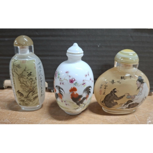 369 - Porcelain snuff bottle with Cockerill decoration together with two coloured glass Oriental snuff bot... 