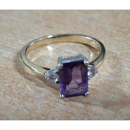 188 - 9ct yellow gold ring with a large emerald cut Amethyst, flanked to either side by a small round cut ... 