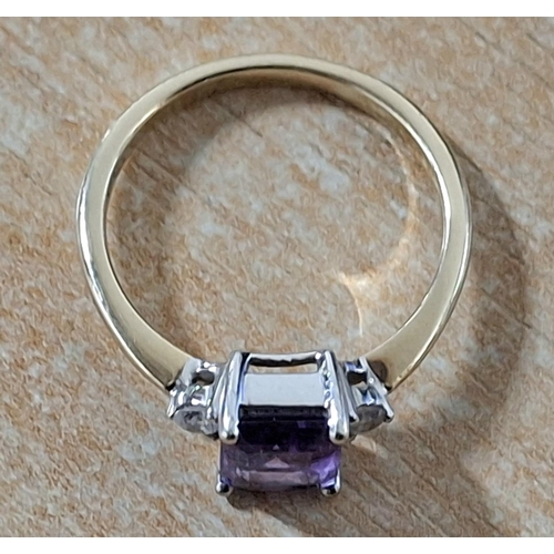 188 - 9ct yellow gold ring with a large emerald cut Amethyst, flanked to either side by a small round cut ... 