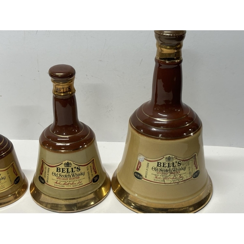 145 - Four bottles of 70% Bells whiskey, each in their iconic 