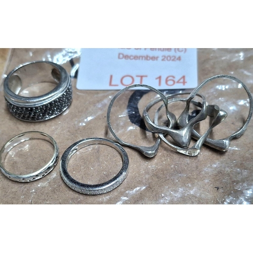 164 - Four various silver rings including an interlinked puzzle ring, approx 22.5 grams (4)