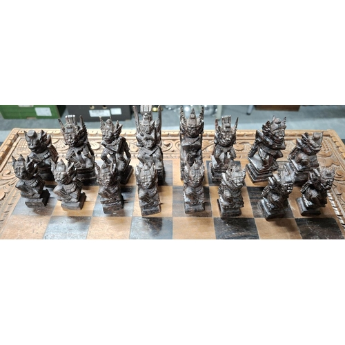 190 - Fine quality chess board with hand-carved Oriental wooden figures with fold-up carry board, also car... 