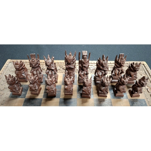 190 - Fine quality chess board with hand-carved Oriental wooden figures with fold-up carry board, also car... 