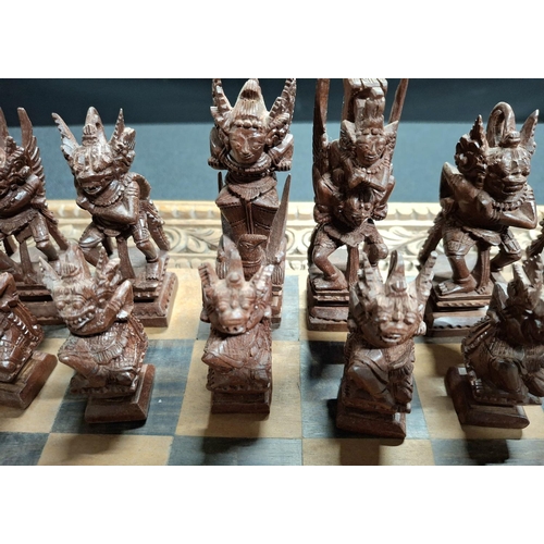 190 - Fine quality chess board with hand-carved Oriental wooden figures with fold-up carry board, also car... 