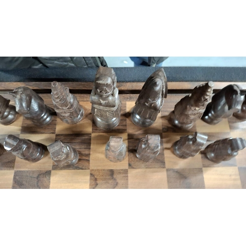 191 - Superb chess board with hand-carved Oriental wooden figures with fold-up carry board, also carved wo... 