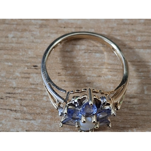 45 - Flower ring with a central oval cut Opal surrounded by Amethyst petals on a yellow gold coloured sha... 