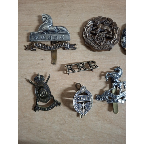 217 - Ten WWII era British military cap badges etc (Qty)