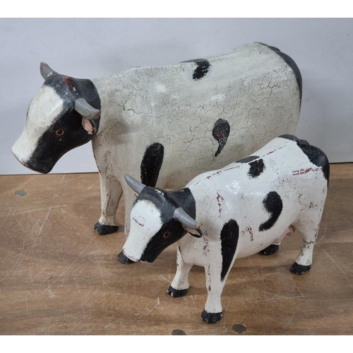 138 - Two over-sized and hand-painted FOLK ART wooden Cows (2),

Largest - approx 33cm long X 22cm tall