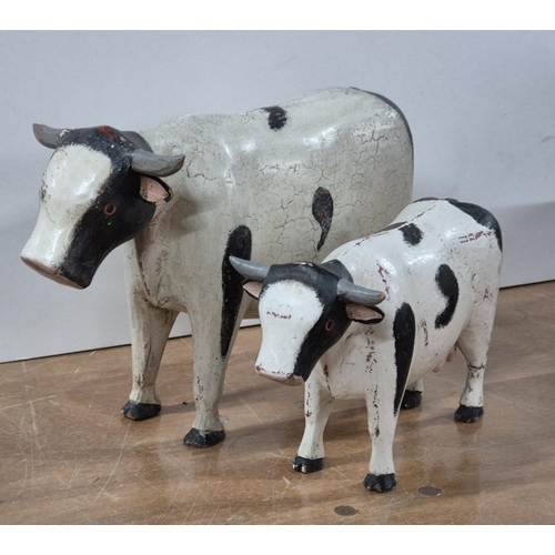 138 - Two over-sized and hand-painted FOLK ART wooden Cows (2),

Largest - approx 33cm long X 22cm tall