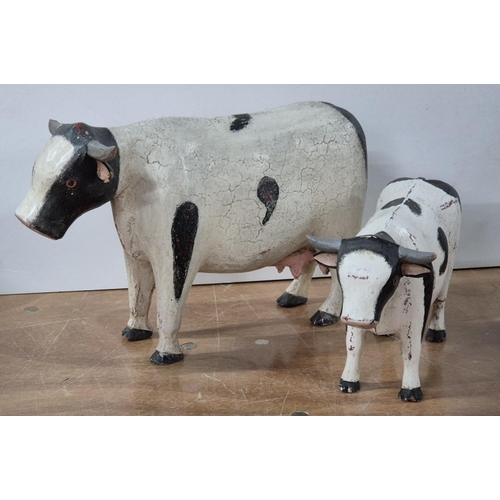 138 - Two over-sized and hand-painted FOLK ART wooden Cows (2),

Largest - approx 33cm long X 22cm tall