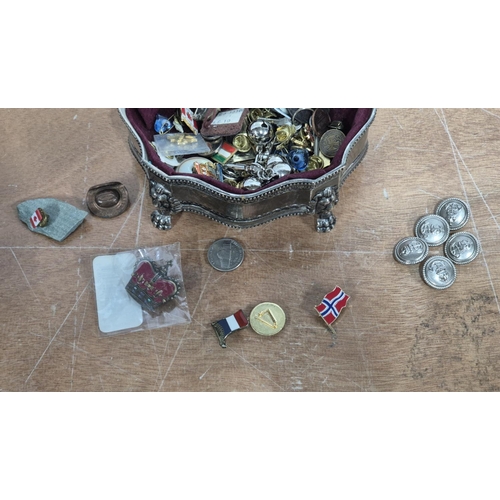 141 - White metal trinket box containing a large quantity of metal buttons and modern enamel badges