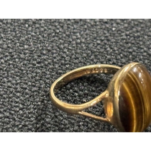 44A - 9ct yellow gold ring with a Tigers Eye Cabochon,

3.3 grams gross