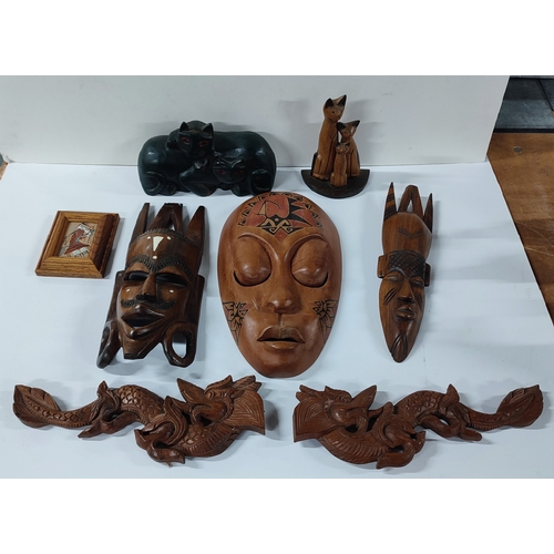 79 - Collection of aboriginal carved wood masks and oriental dragon carvings etc. (Qty)