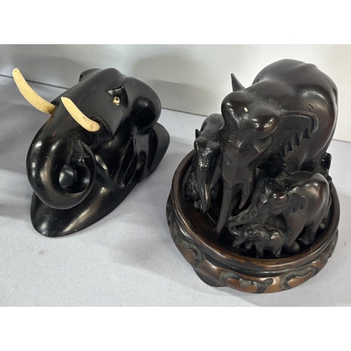 143 - Seven black wooden elephants, one on a stand (7)