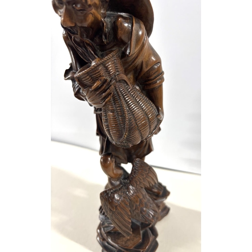 87 - 19thC Chinese root carving depicting an old man carrying a basket whilst walking on an rocky path wi... 