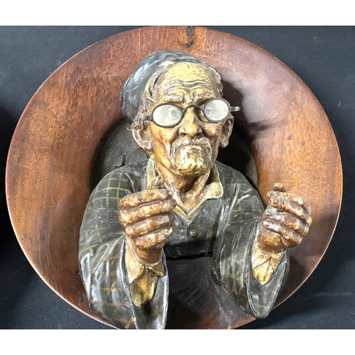 93 - Pair of large, early 20thC 3-D wooden circular wall plaques in the form of a man and woman, probably... 