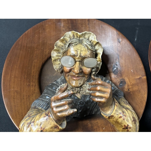 93 - Pair of large, early 20thC 3-D wooden circular wall plaques in the form of a man and woman, probably... 