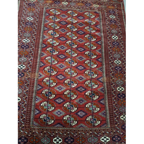 213 - Superb quality red ground woven wool patterned rug with short white tasselled ends, possibly middle-... 