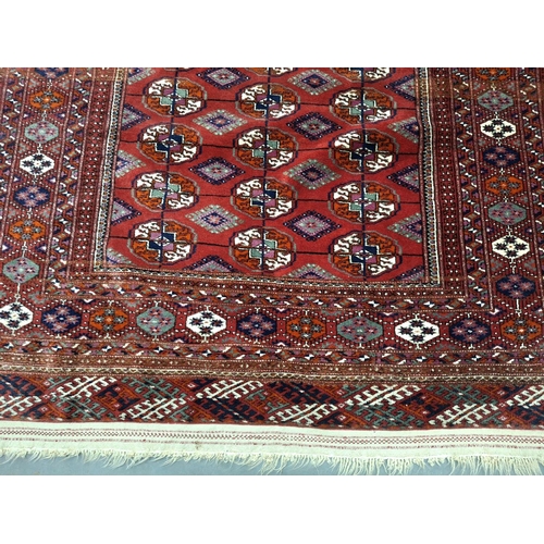 213 - Superb quality red ground woven wool patterned rug with short white tasselled ends, possibly middle-... 