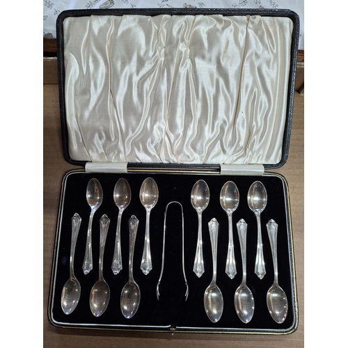 17 - Cased set of 12 hallmarked 1924 Birmingham silver tea spoons together with a sugar nip,

155 grams