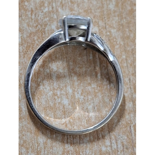 39 - 9ct white gold ring with a large CZ and smaller stones to both shoulders,

2.4 grams gross