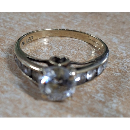 40 - 9ct yellow gold ring with a large CZ and smaller stones to both shoulders, 

3 grams gross