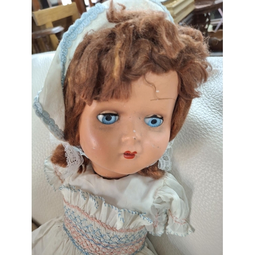 569A - Early cloth and straw filled doll together with an unmarked mid 20thC porcelain, blue eyed doll and ... 