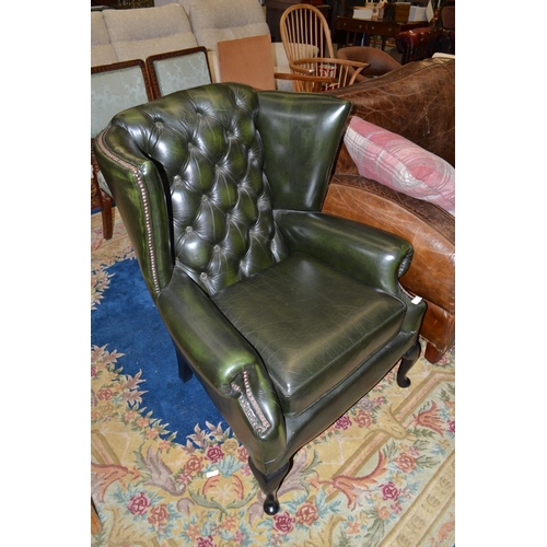 885 - Green leather wing backed arm chair