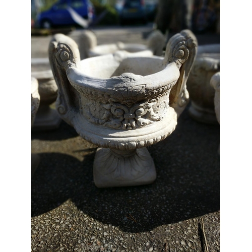 167 - Large handled urn on fluted square base with a chasing floral relief to sides